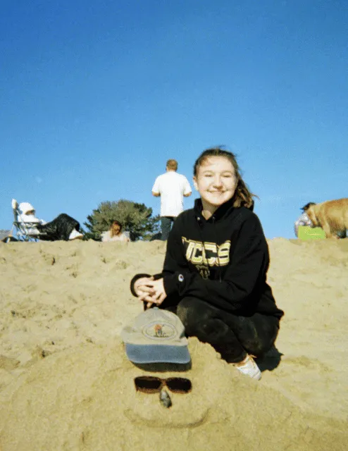 Photo of Amanda Orchard. Shes wearing a UCCS sweatshirt and is at a beach. She is smiling and has in a ponytail